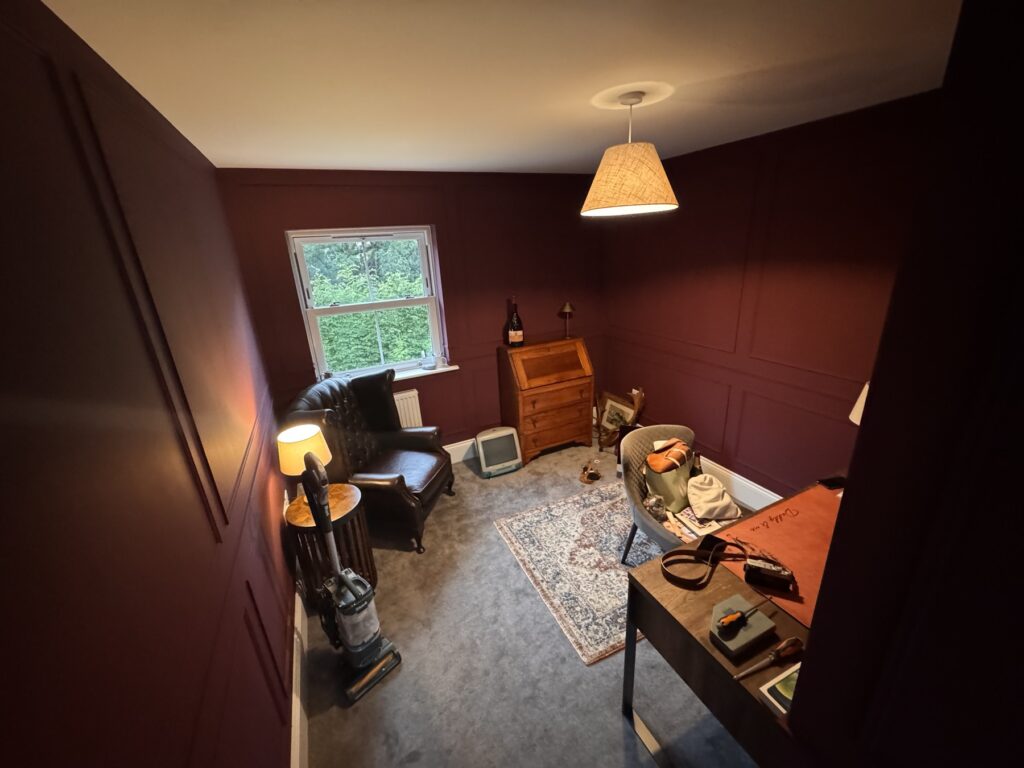 Home study with wall panelling painted deep burgundy