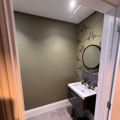 Cloakroom with botanical wallpaper and dark vanity unit