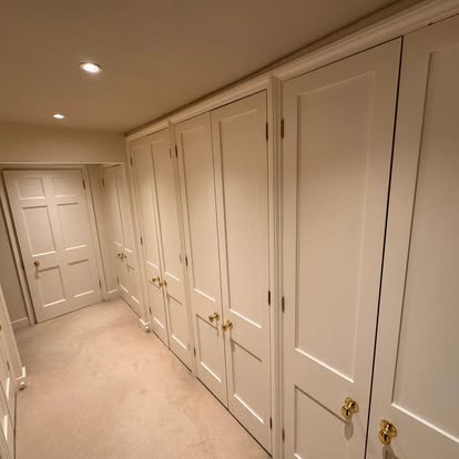 Row of fitted wardrobes painted in cream