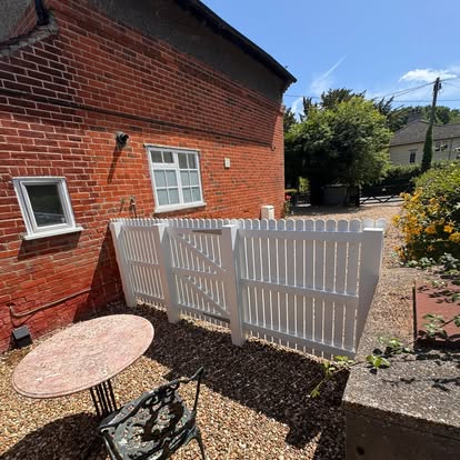 White painted gates and fence at a brick cottage