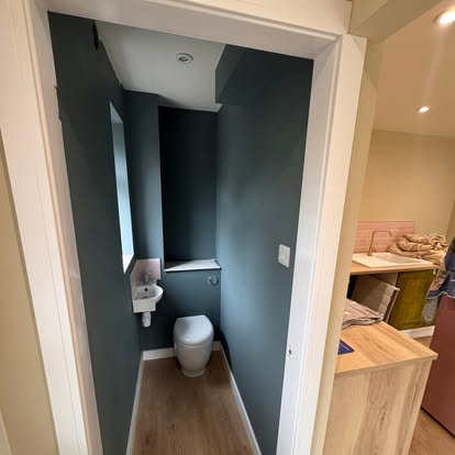 Cloakroom painted in deep teal