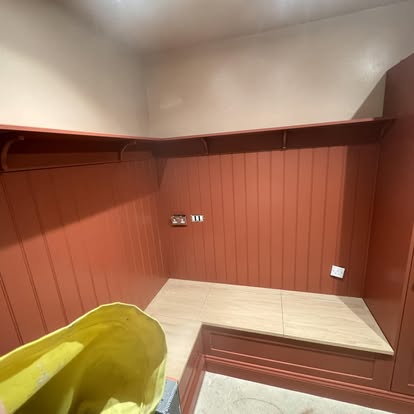 Terracotta panelled boot room with bench