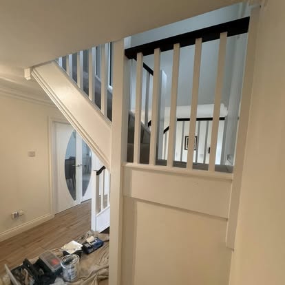 Staircase with white spindles and dark handrail