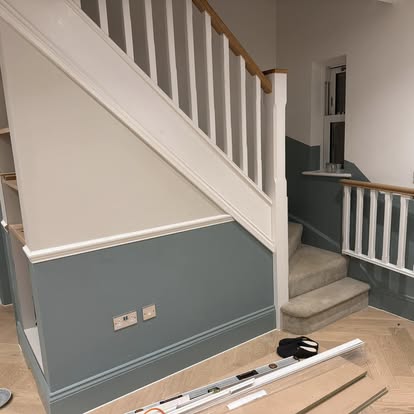 Staircase with blue-grey panelling and white spindles