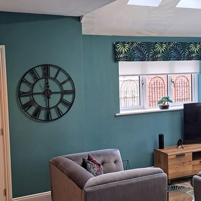 Living room with teal feature wall and clock