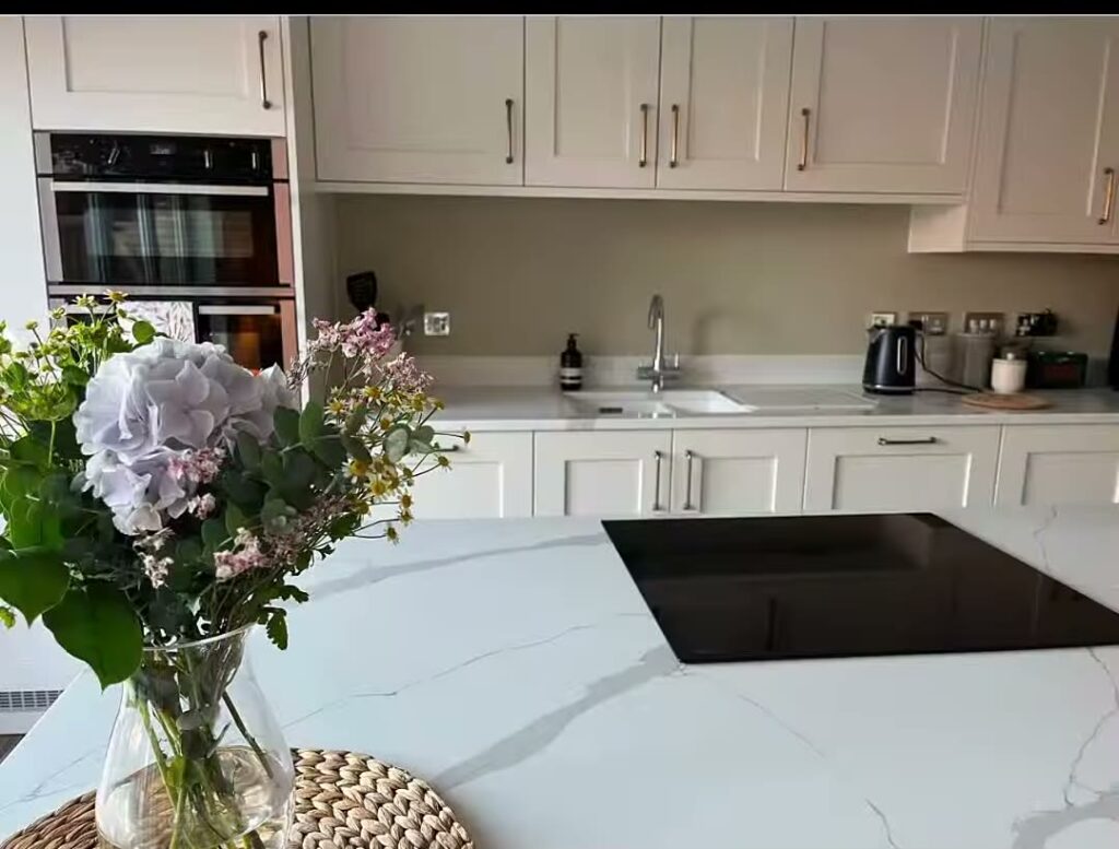 Kitchen with cream cabinets and quartz island after decorating