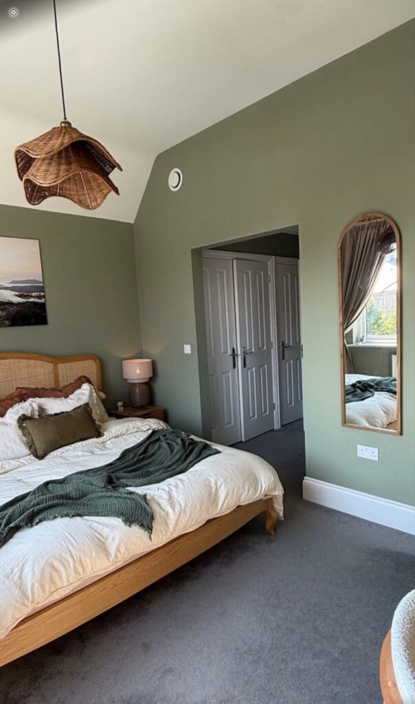 Sage green bedroom with white panelled wardrobe doors