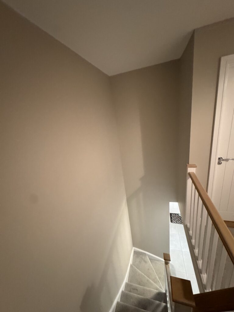 Top of the stairs with oak handrail and white spindles