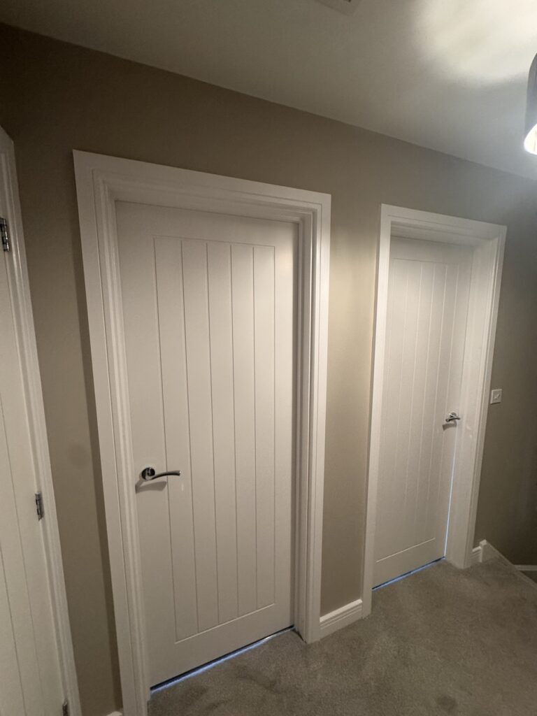 White cottage-style doors on a freshly painted landing